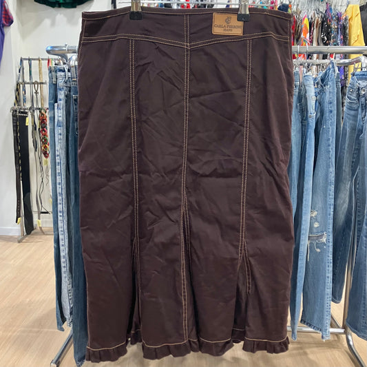 Brown skirt hanging on a rack with jeans in a store setting