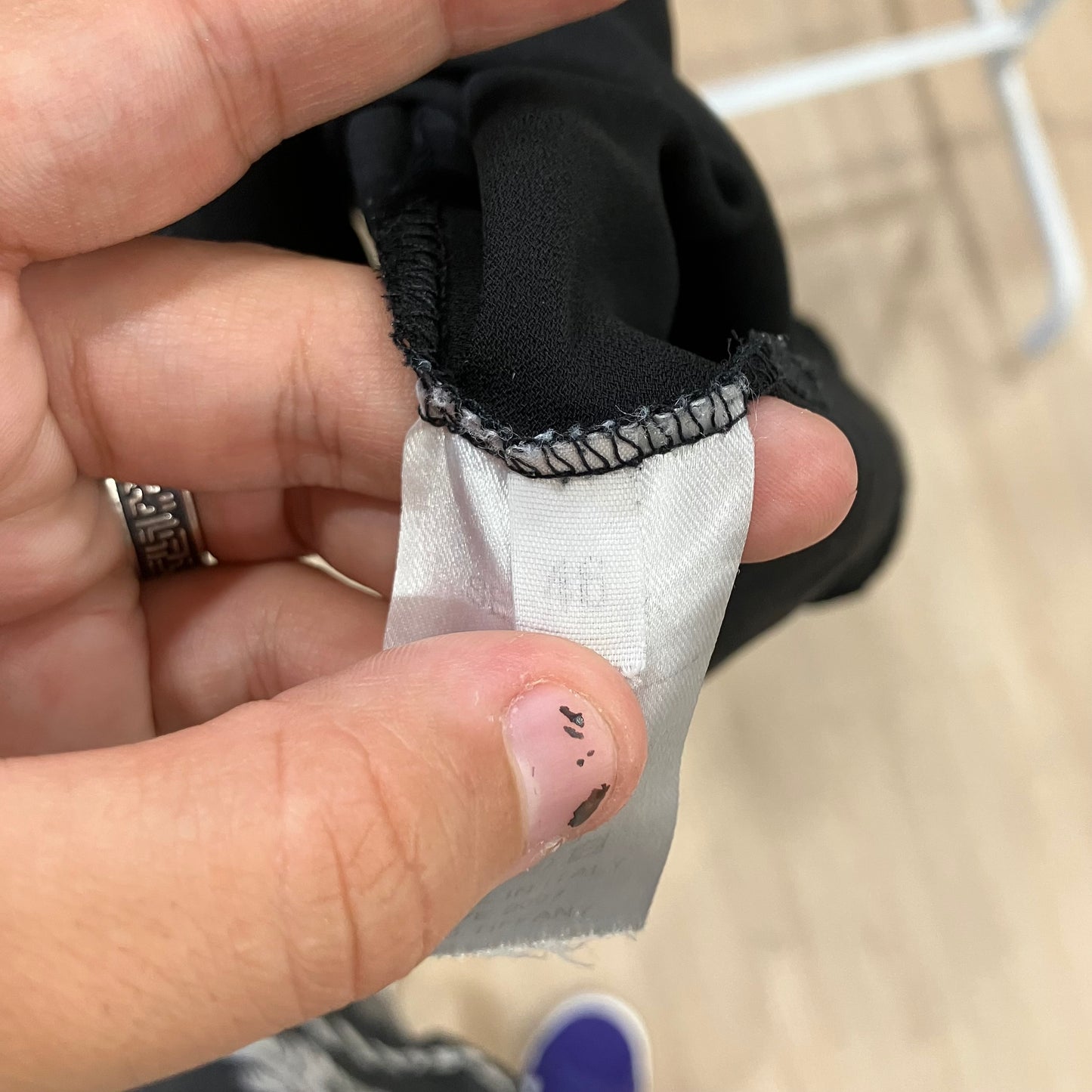 Close-up of a hand holding a label with text on a blurred background