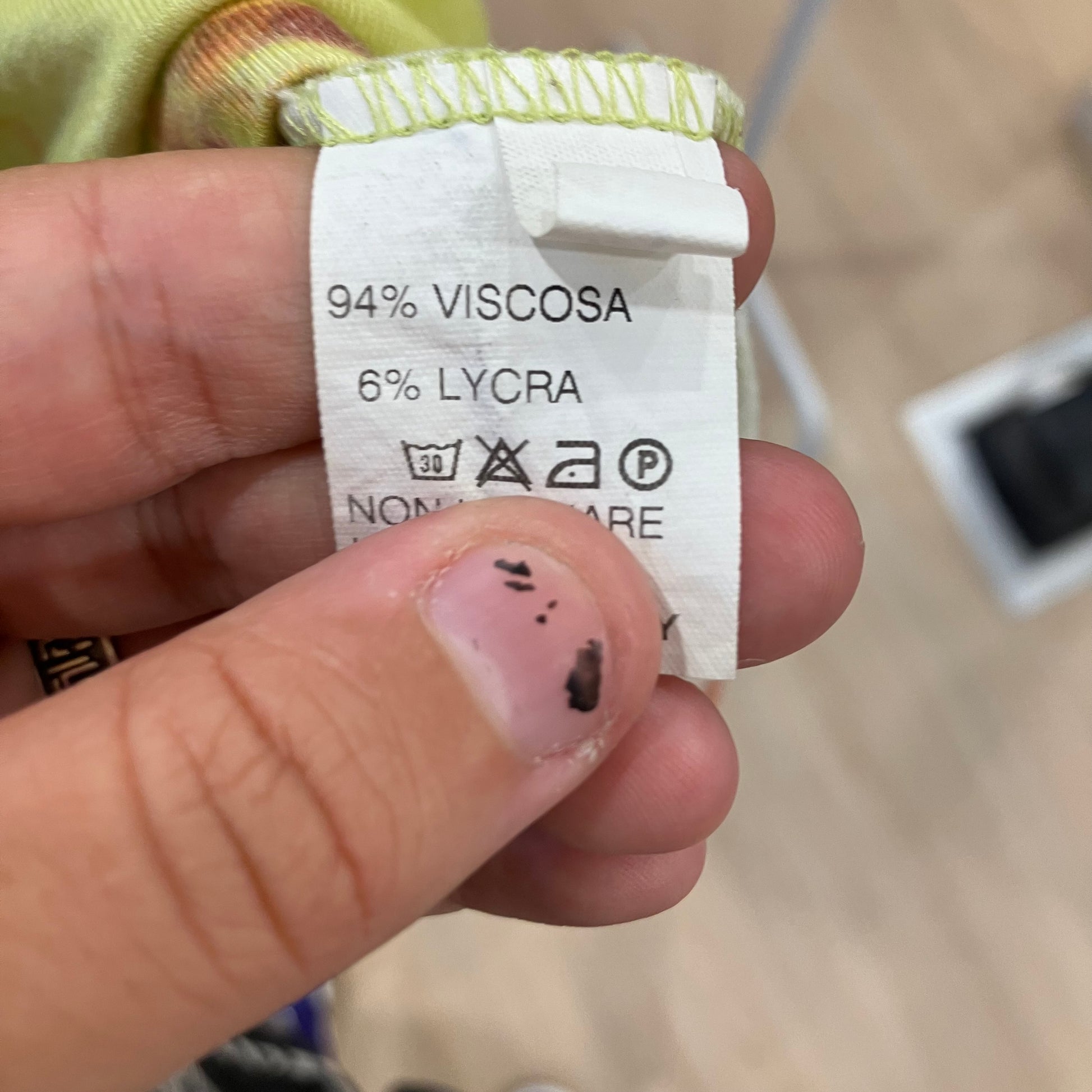 Hand holding a fabric label with material composition details