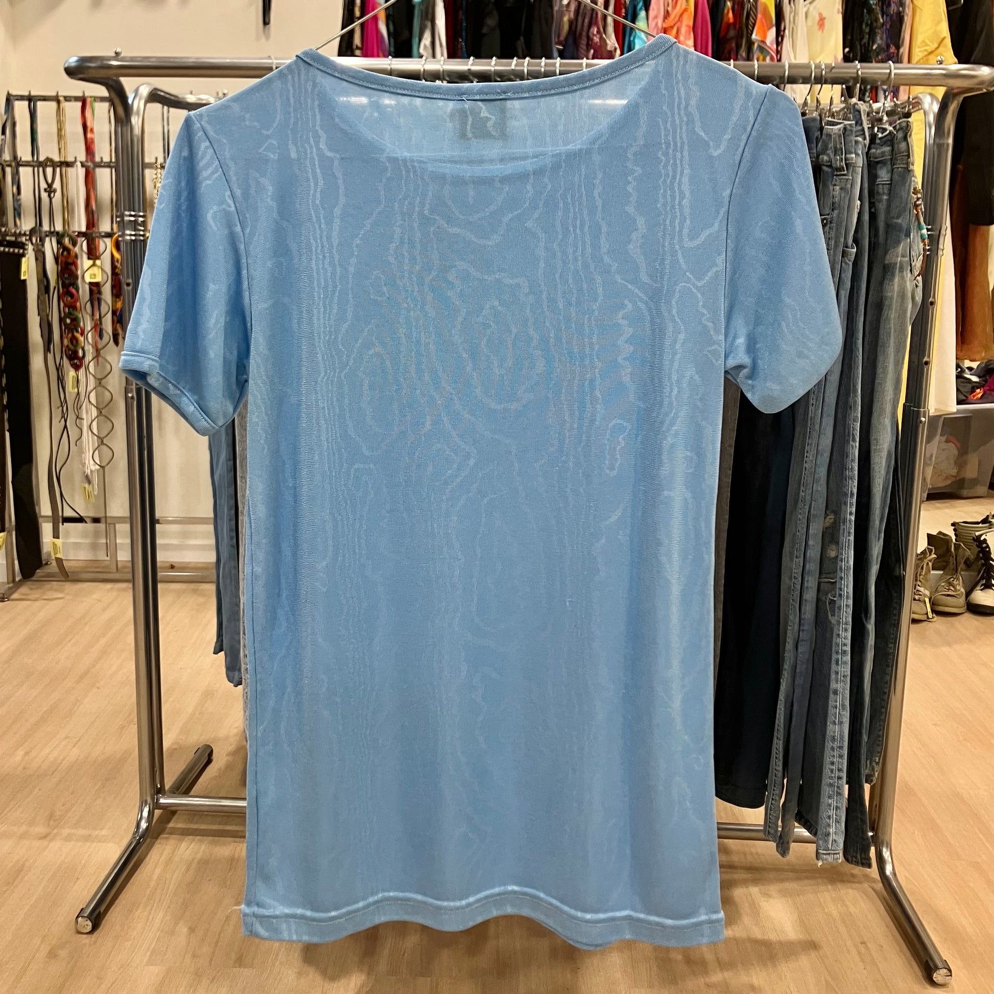 Blue t-shirt on a rack in a store setting