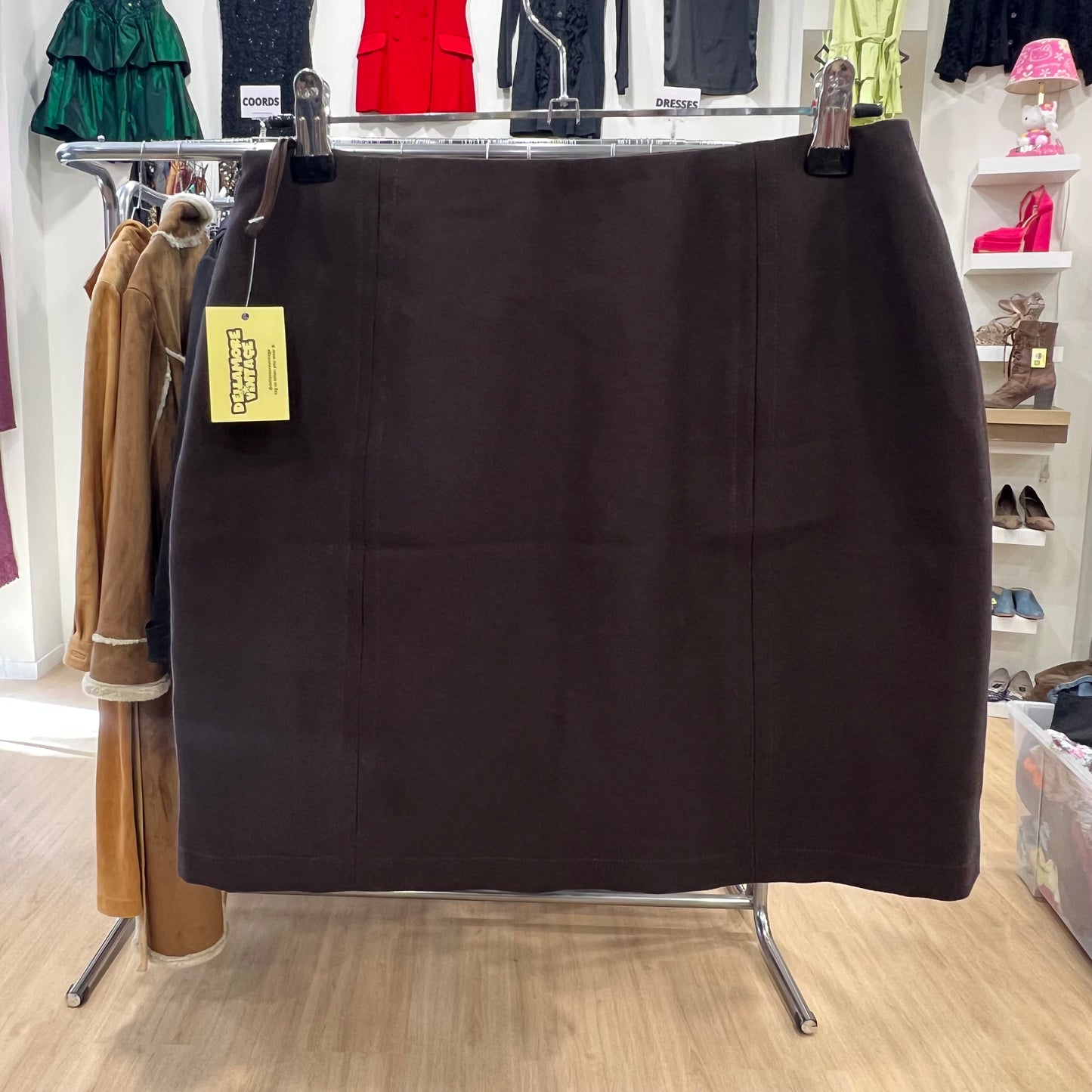 Black skirt on a rack in a store with various clothing items in the background