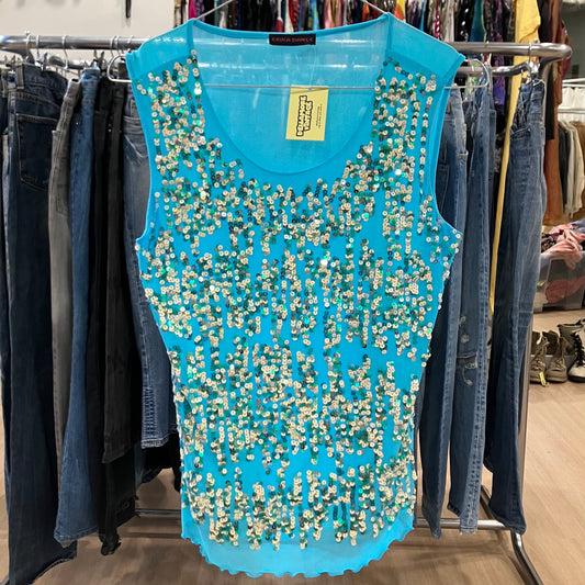 Blue beaded top on a rack with jeans in a store setting
