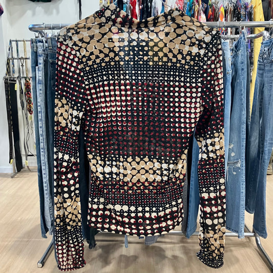 Patterned top on a rack with jeans in a store setting