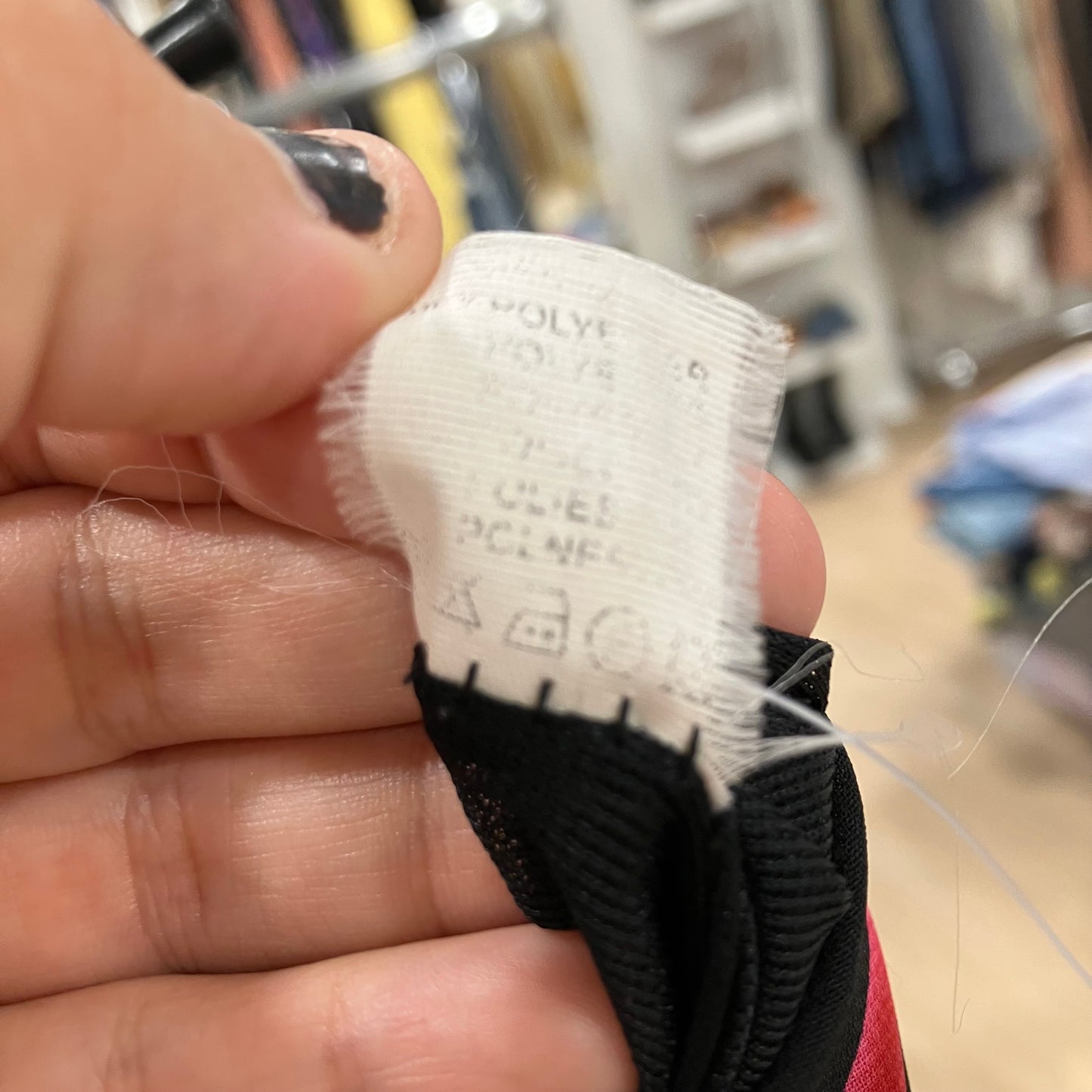 Close-up of a label on a product held by a hand in an indoor setting