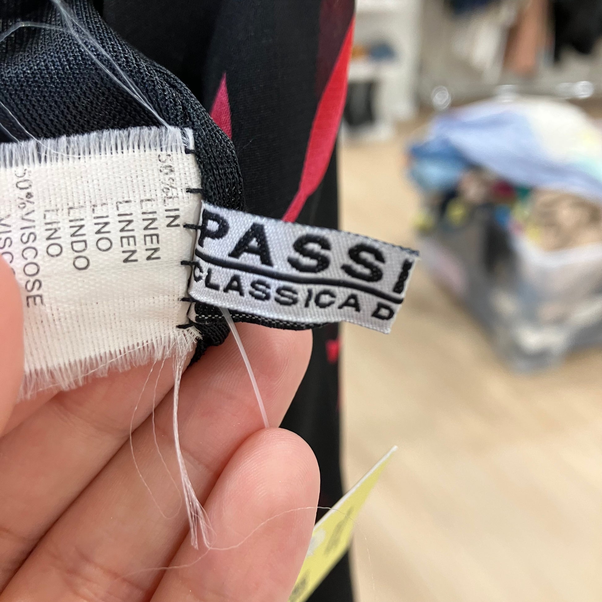 Close-up of a fabric label with 'Passi Classica' on a blurred background