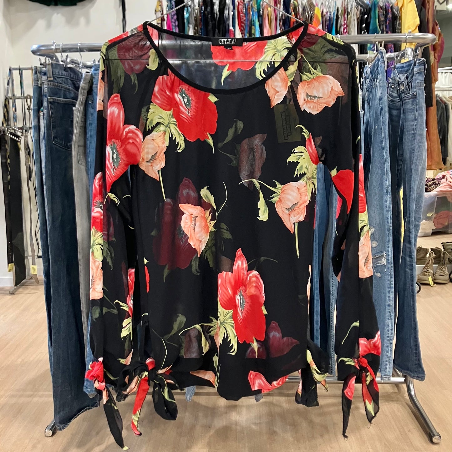Floral dress on a rack with jeans in a store setting