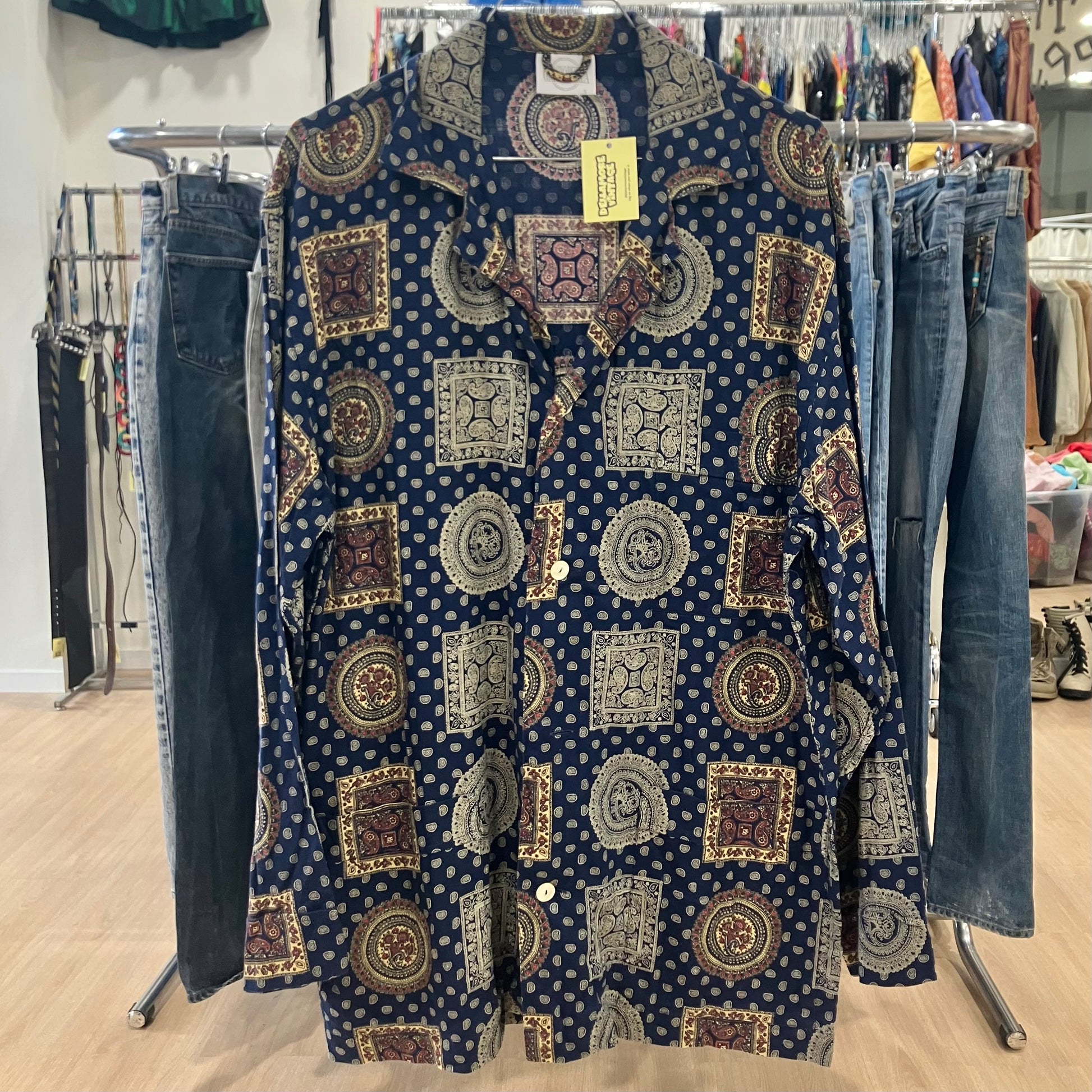 Patterned shirt on a rack with jeans in a store setting