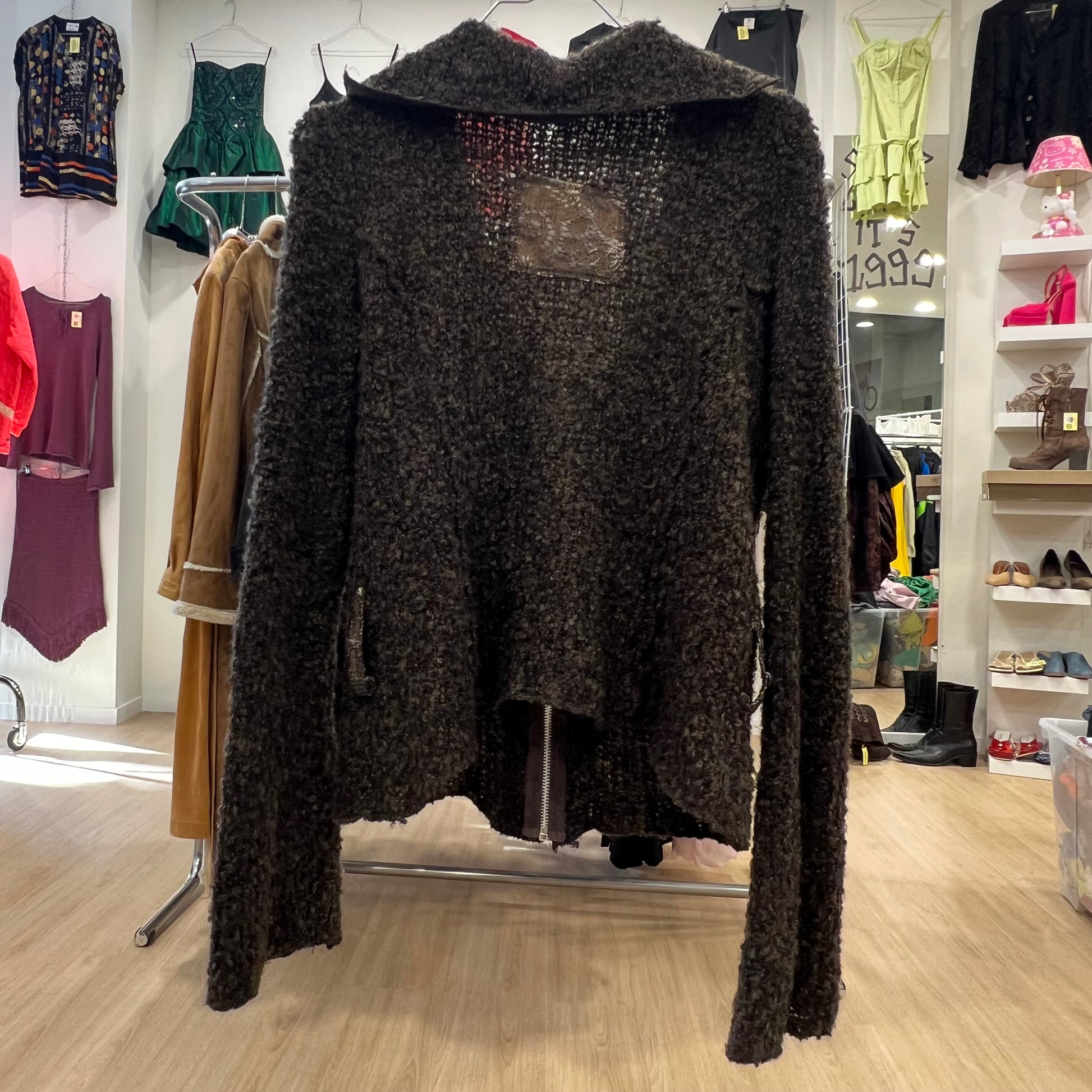 Dark textured sweater on a mannequin in a clothing store setting