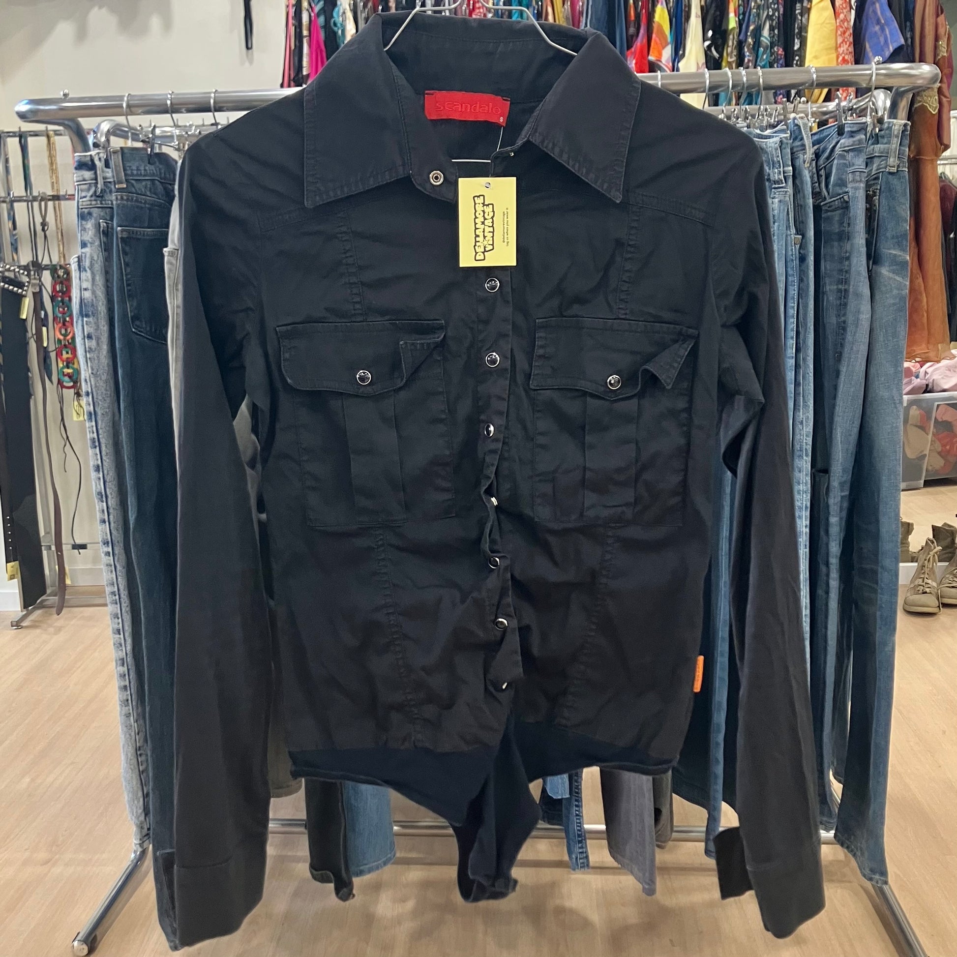 Black shirt with a tag on a rack in a store