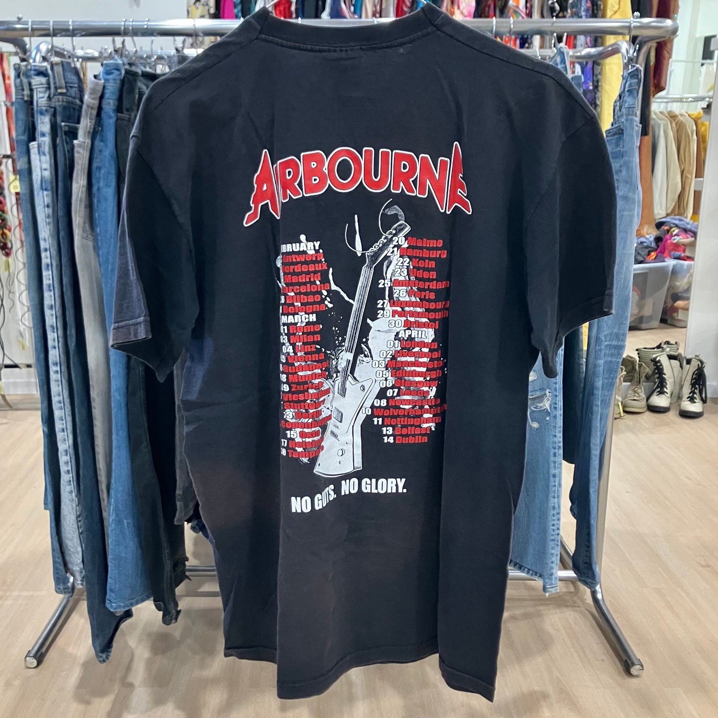 Black t-shirt with graphic design and 'Airbourne' text on a clothing rack