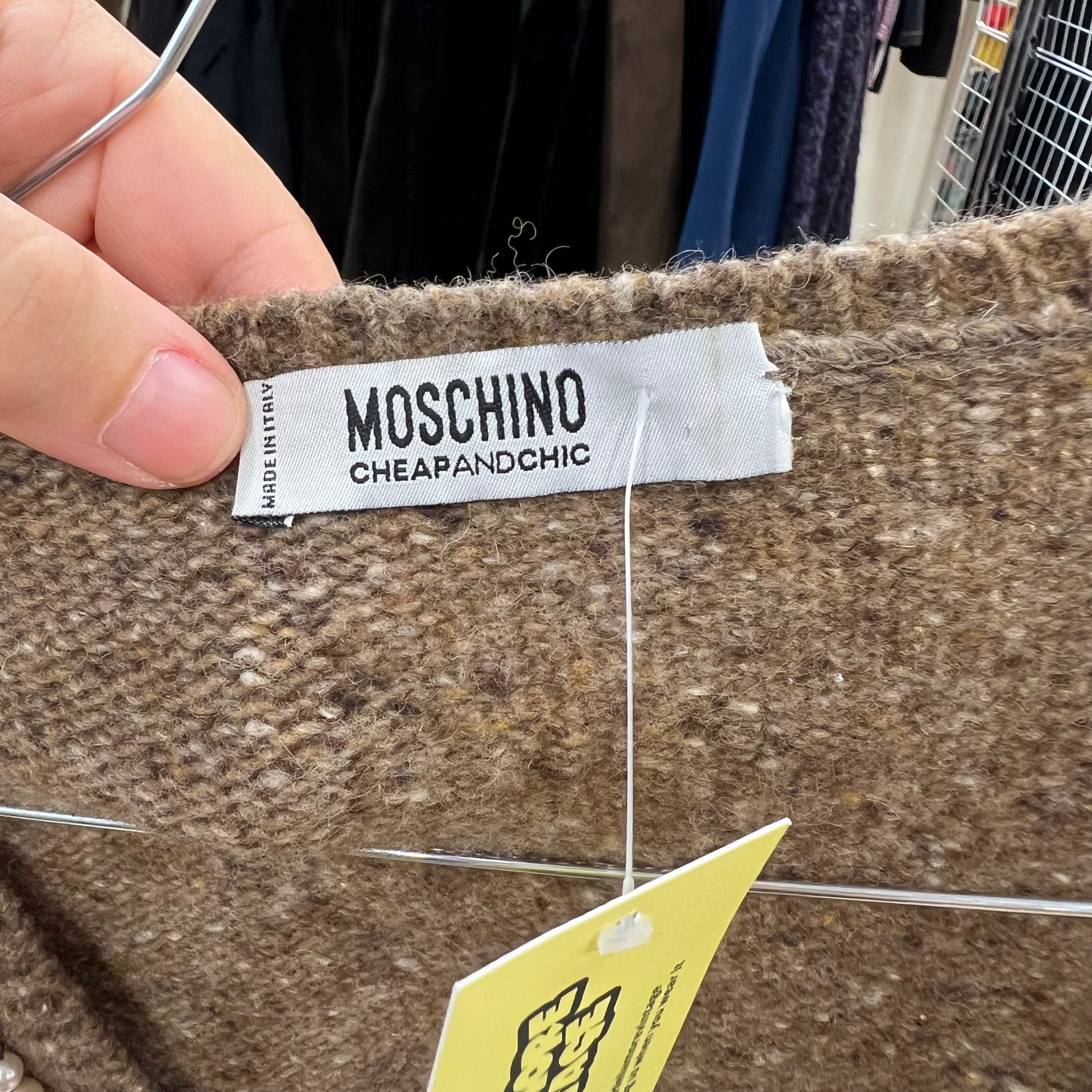 MOSCHINO label on a textured fabric with a yellow tag.