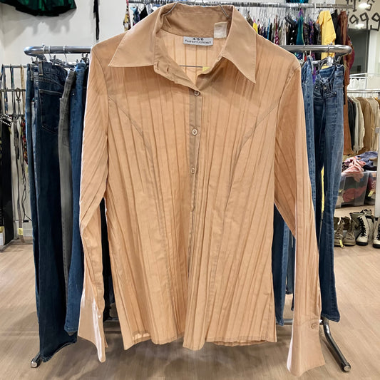 Beige button-up shirt on a rack with jeans in the background