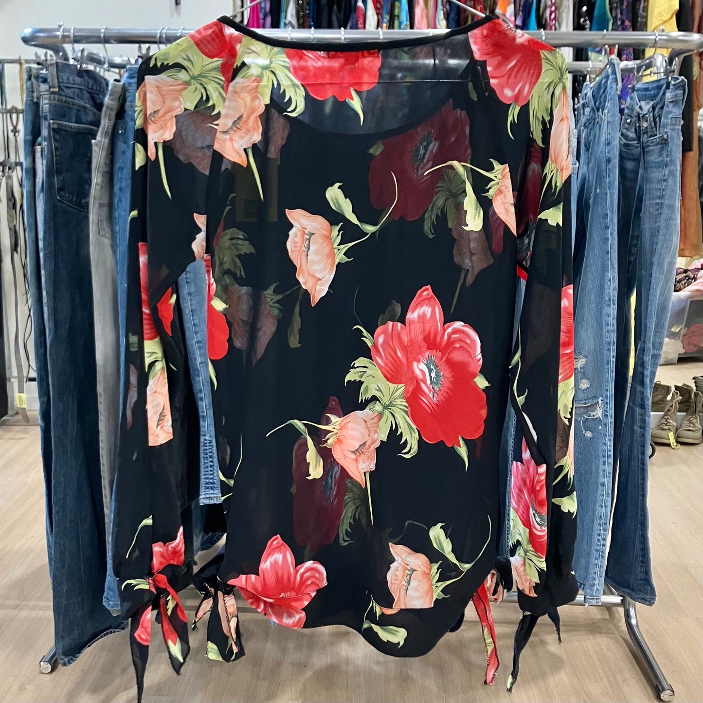 Floral dress on a rack with jeans in a store setting