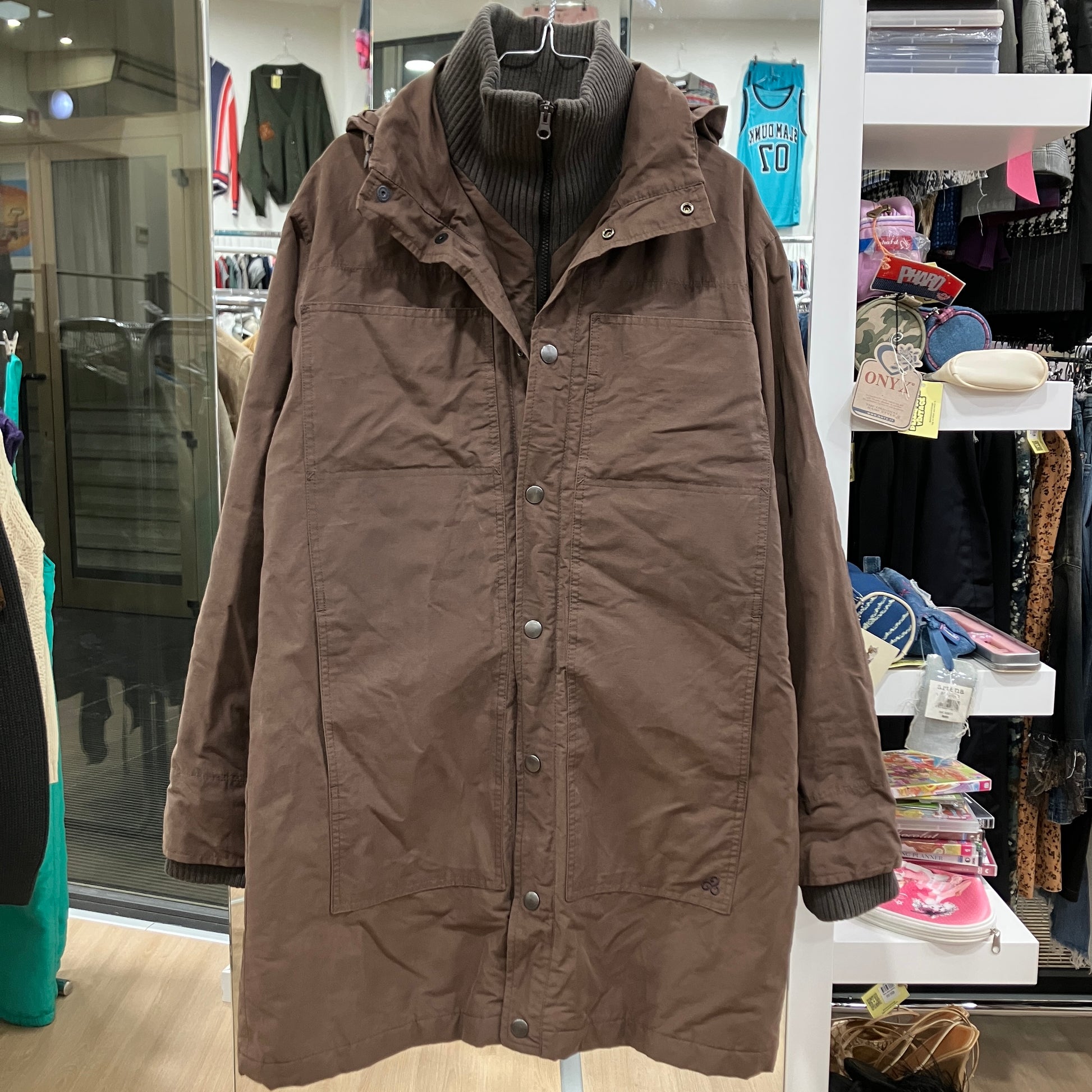 Brown coat on a hanger in a store setting