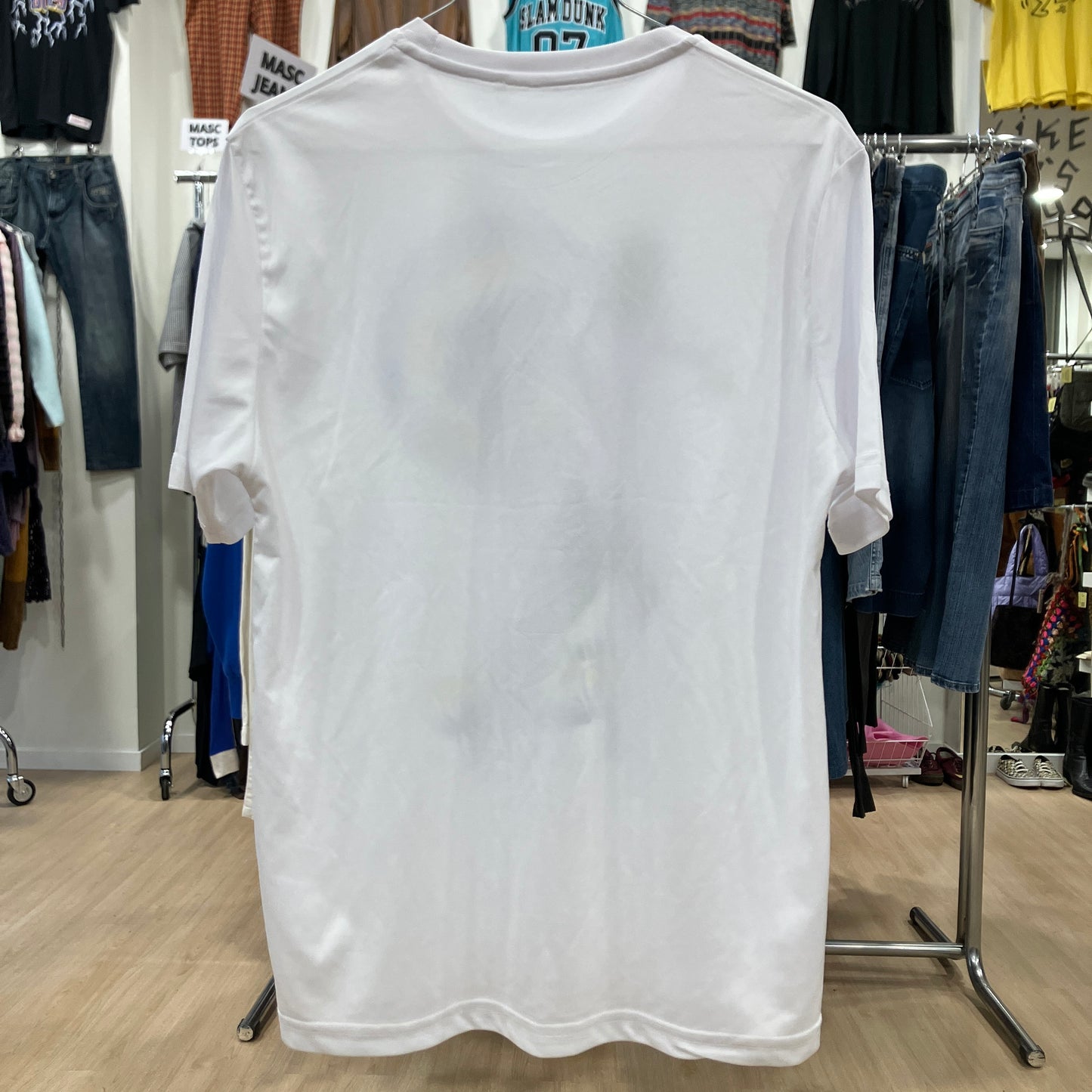 White t-shirt on a hanger in a clothing store setting
