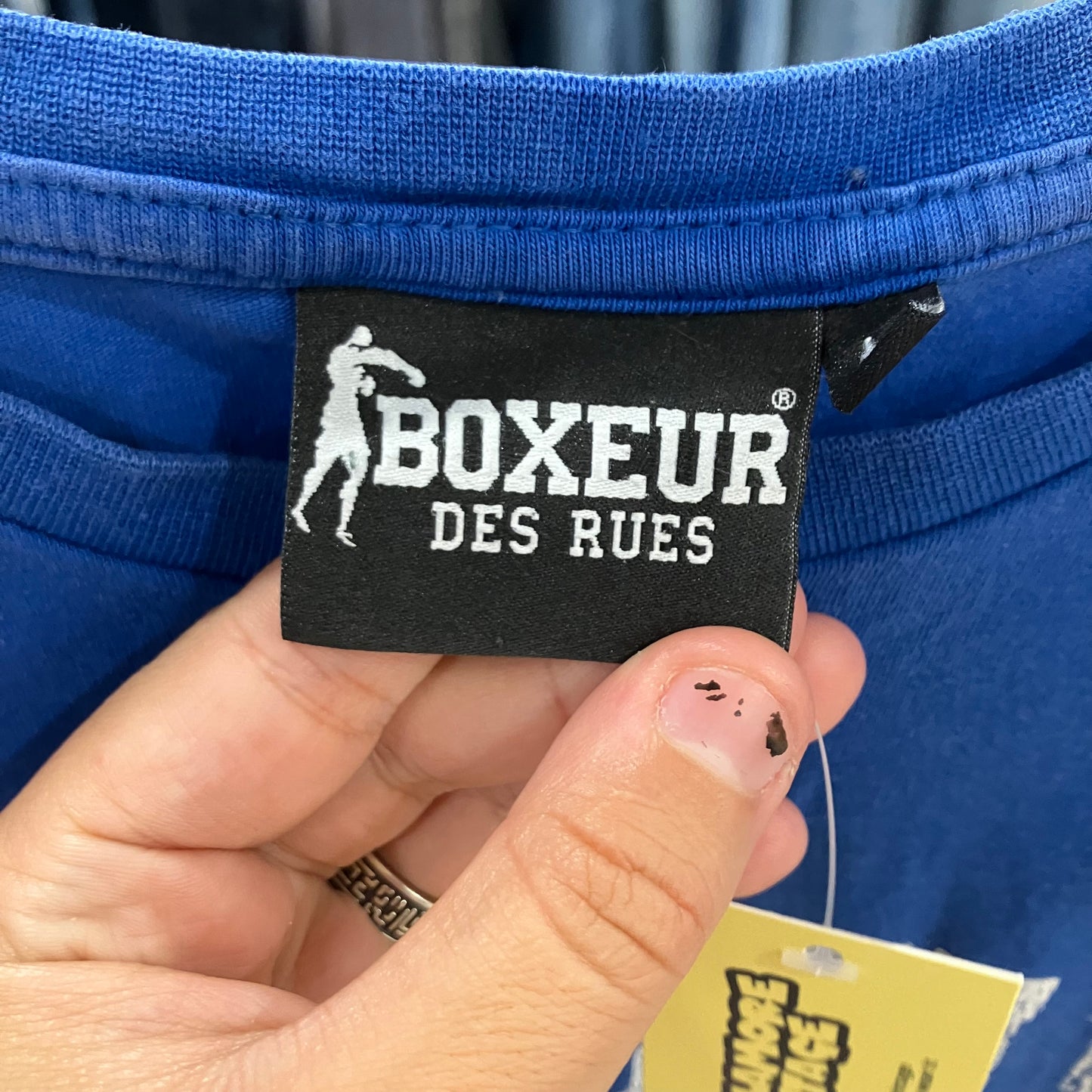 Close-up of a 'Boxeur des Rues' label on blue fabric