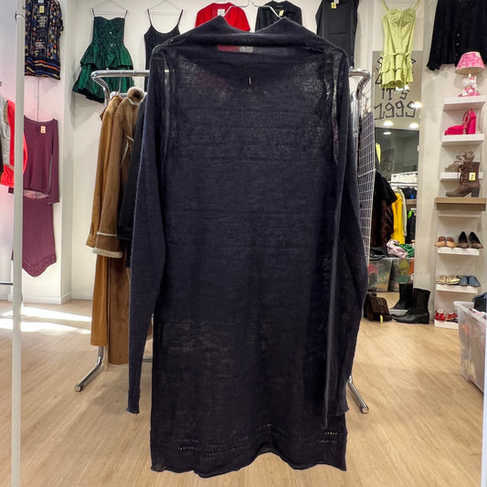 Black dress on a hanger in a clothing store with various garments in the background