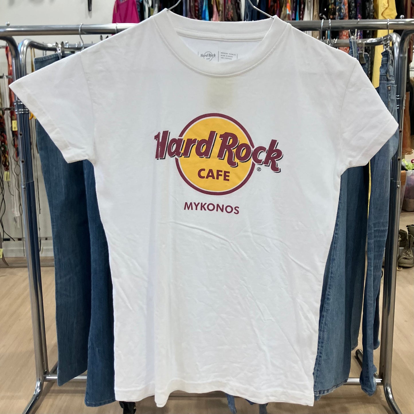 White t-shirt with 'Hard Rock Cafe Mykonos' logo on a clothing rack