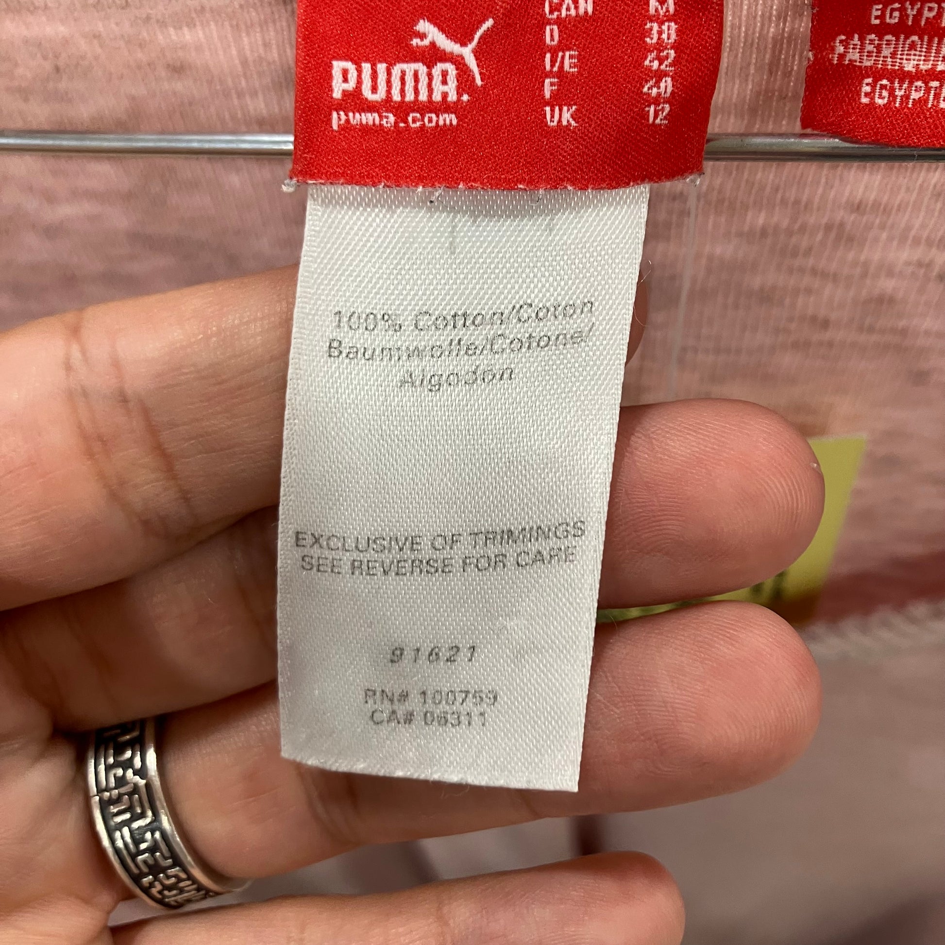 Puma label held by a hand with a blurred background