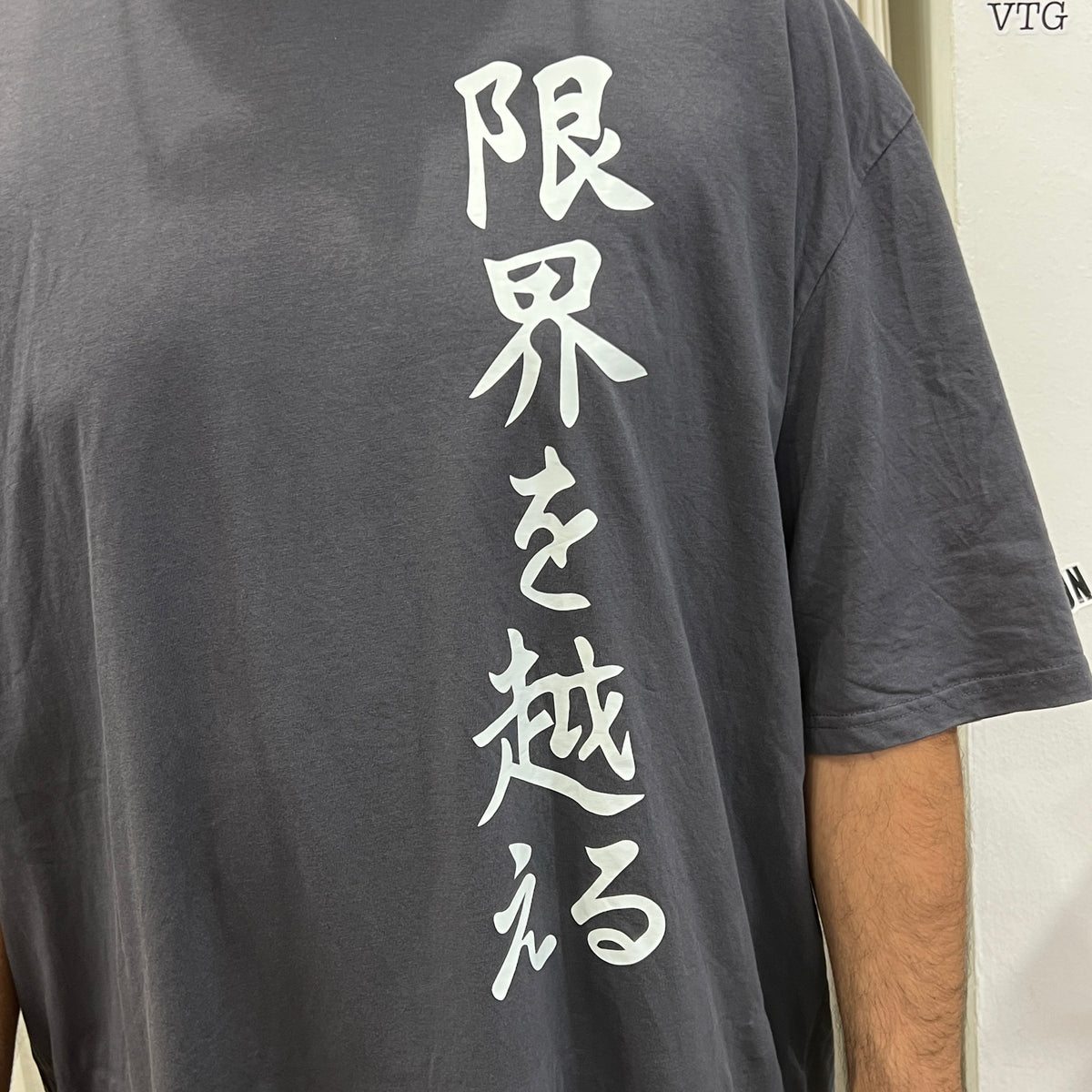 karate event merch grey tshirt with white japanese writing: go beyond your limits