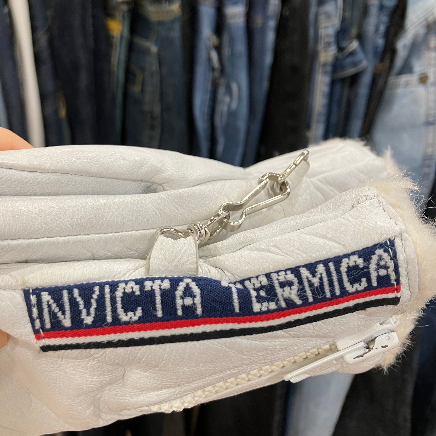 White quilted jacket with 'Invicta Termica' logo on a clothing rack background