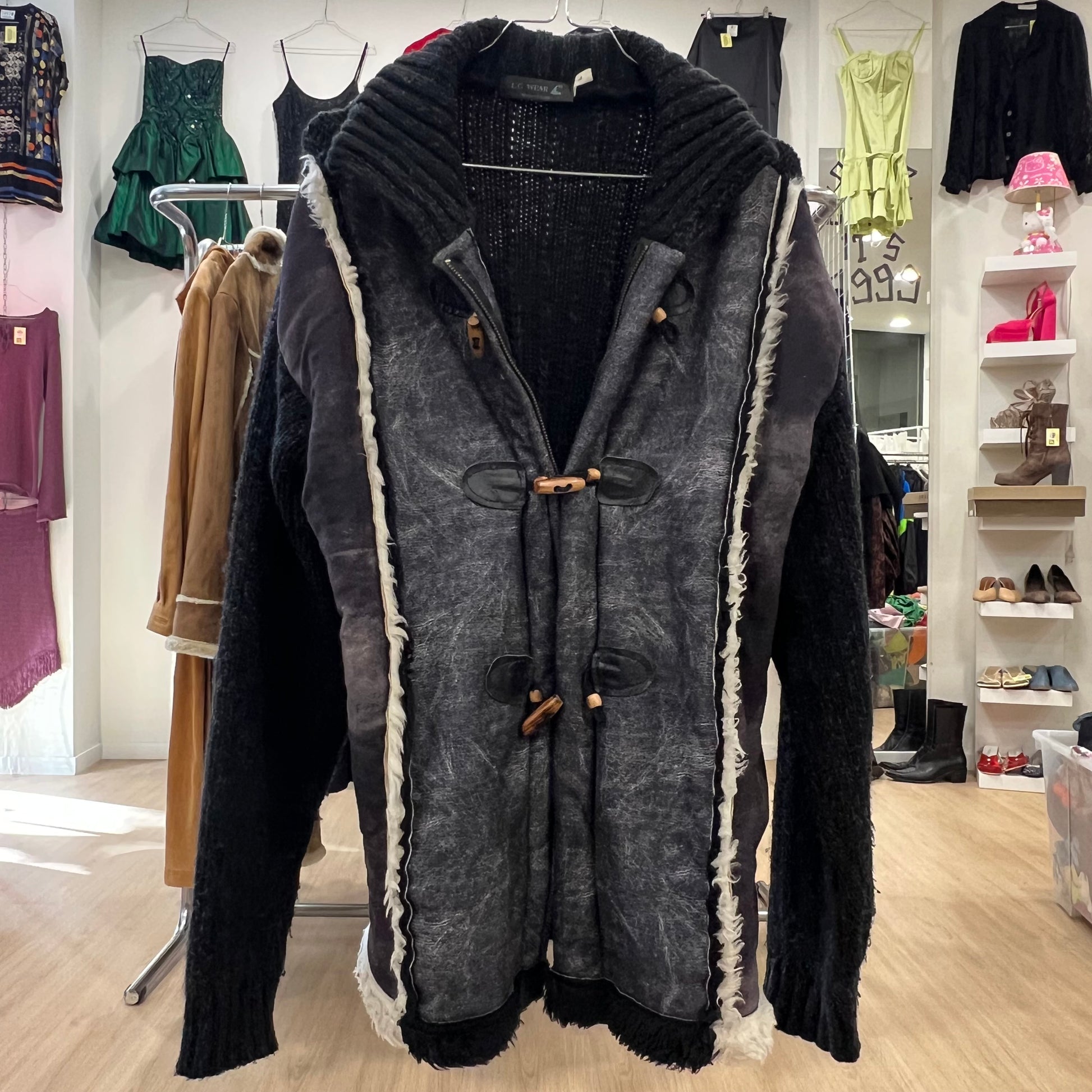 Long dark cardigan with white trim in a clothing store setting