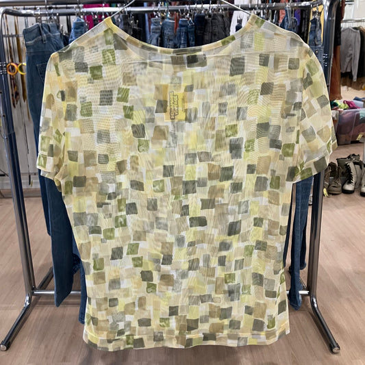 Green and yellow patterned shirt on a rack in a store setting