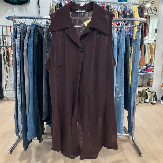 Brown trench coat hanging on a rack with jeans in a store setting