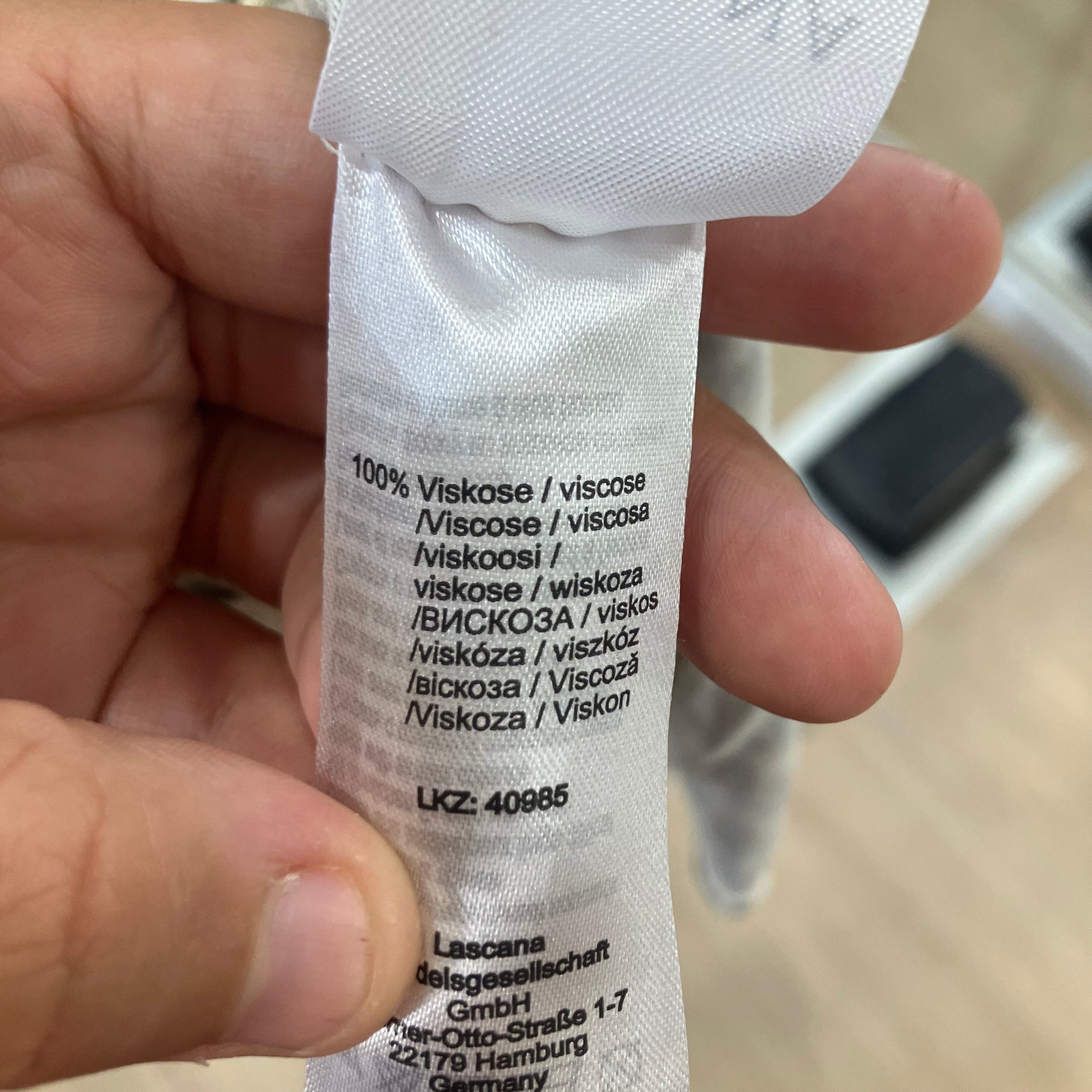 White label with text held by a hand, blurred background