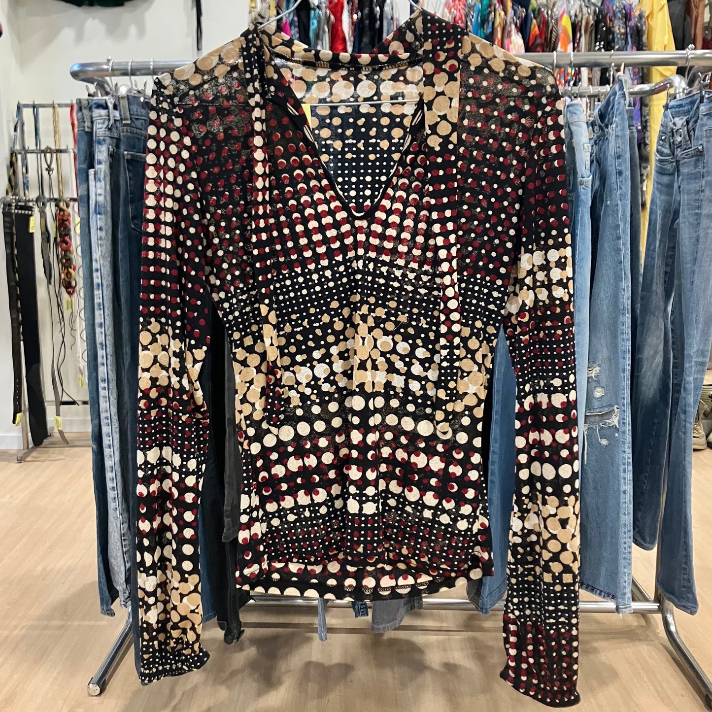 Patterned top on a rack with jeans in a store setting