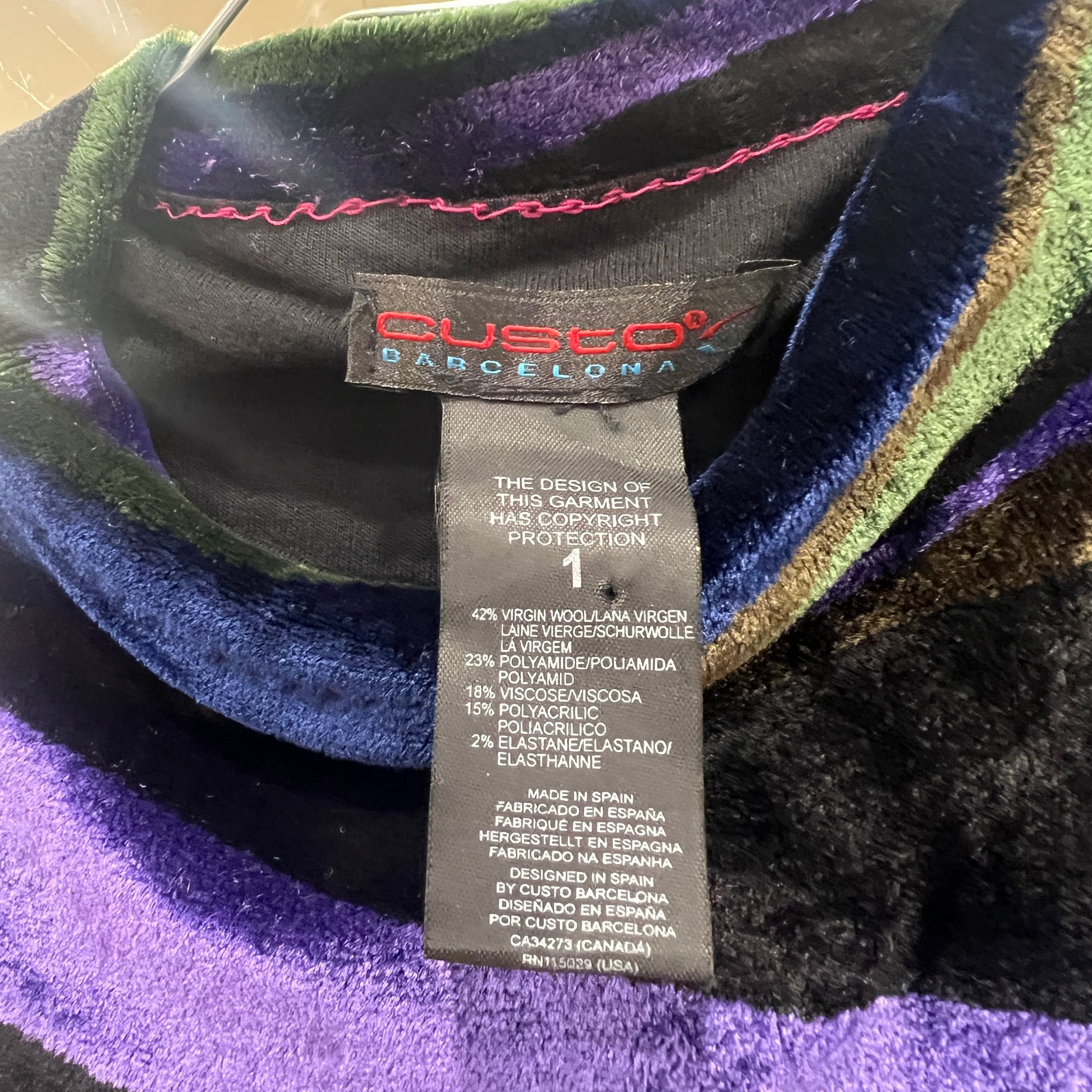 Close-up of a Custo Barcelona label on a multicolored garment with visible text