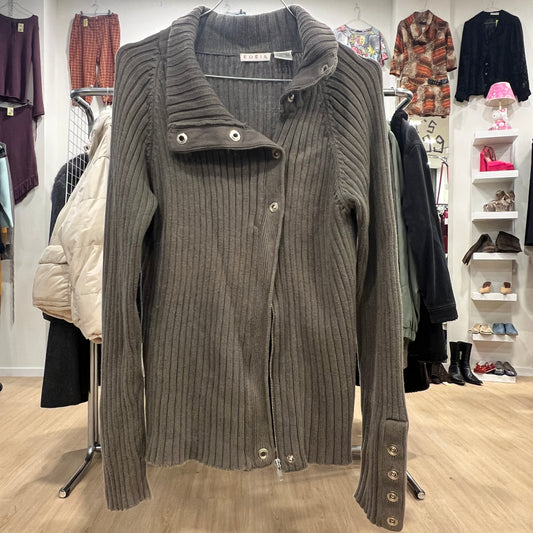 Green ribbed sweater on a hanger with a clothing store background