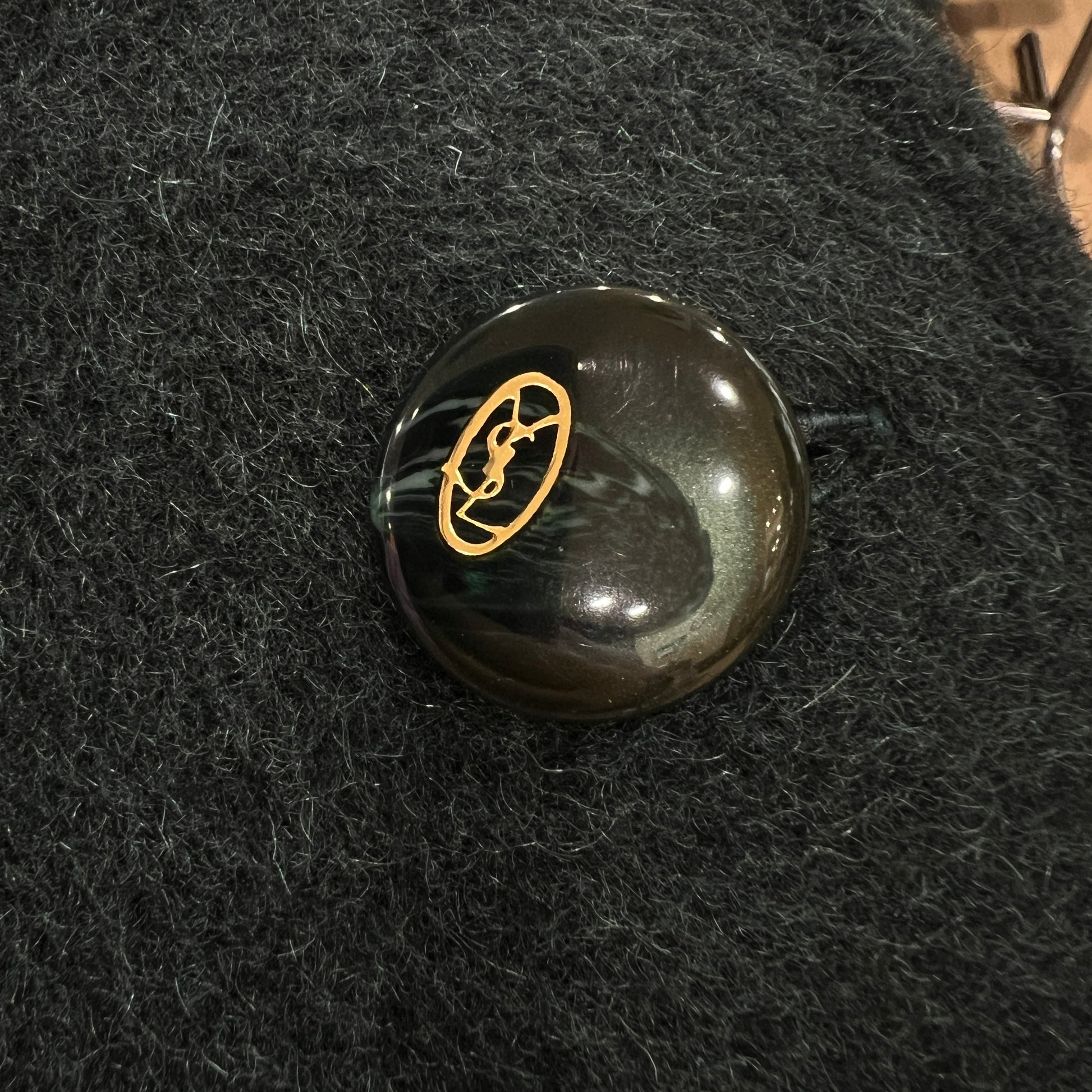 Black stone with gold emblem on a textured black surface