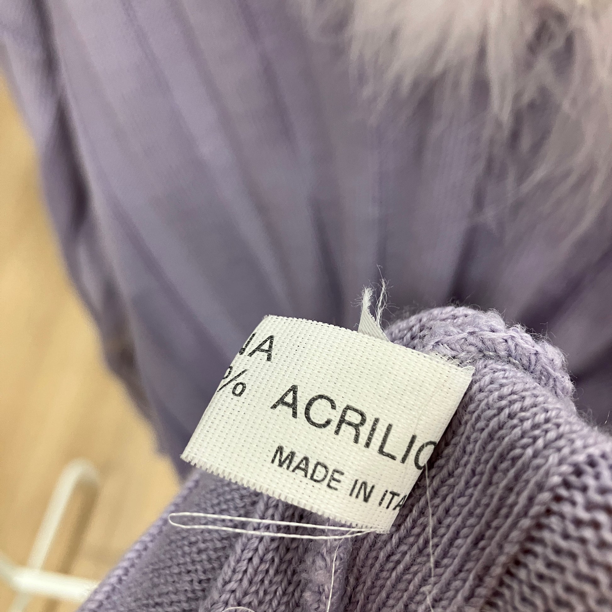 Textile label on a purple fabric with 'ACRILICO MADE IN ITALY' text