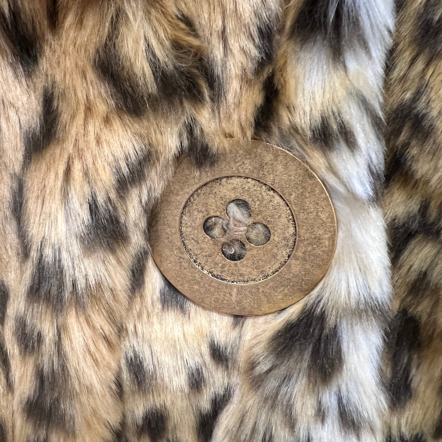 Close-up of a button on a fur surface with a leopard print pattern