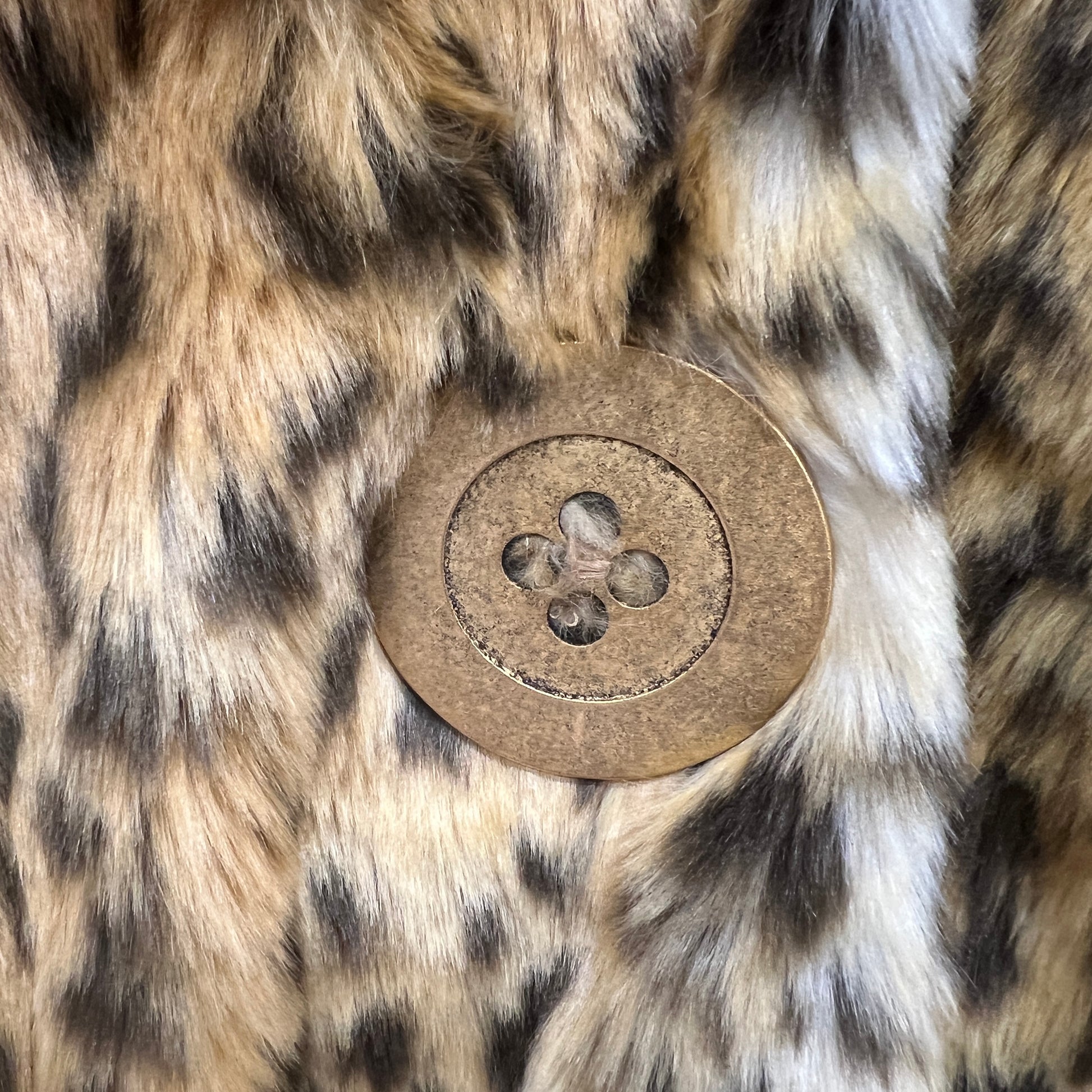 Close-up of a button on a fur surface with a leopard print pattern