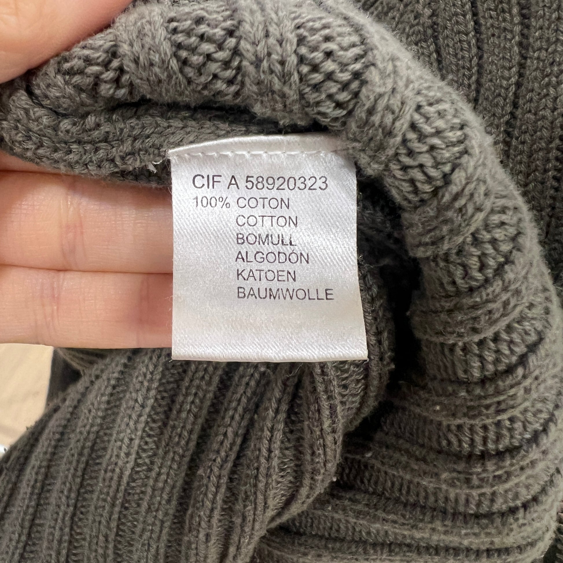 Green knitted fabric with a label indicating 100% cotton