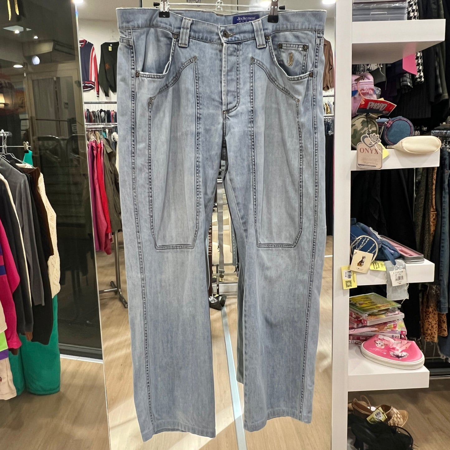 Light blue jeans hanging in a store with various clothing items in the background