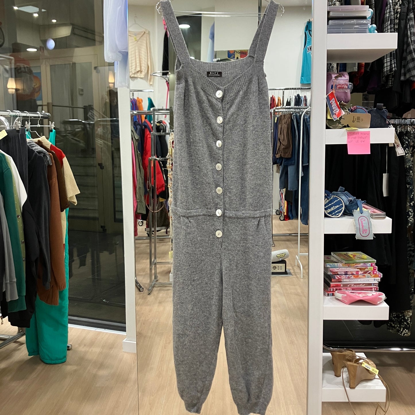 Gray jumpsuit with button details displayed in a store setting