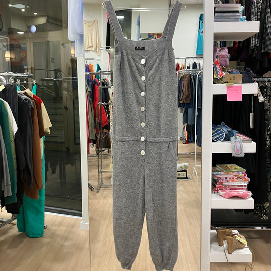 Gray jumpsuit with button details displayed in a store setting
