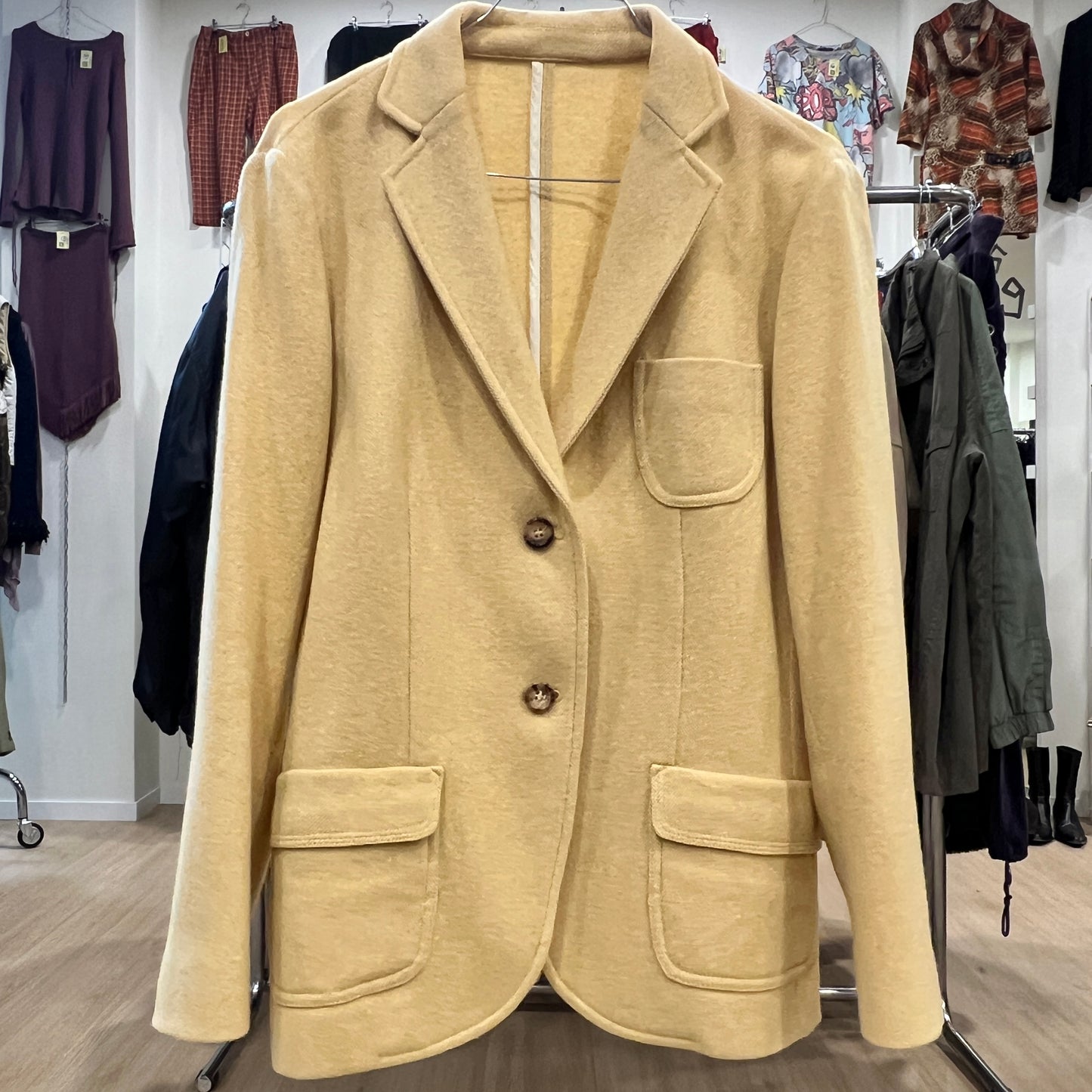 Beige blazer on a rack with a clothing store background