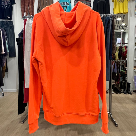 Orange hoodie on a rack in a clothing store