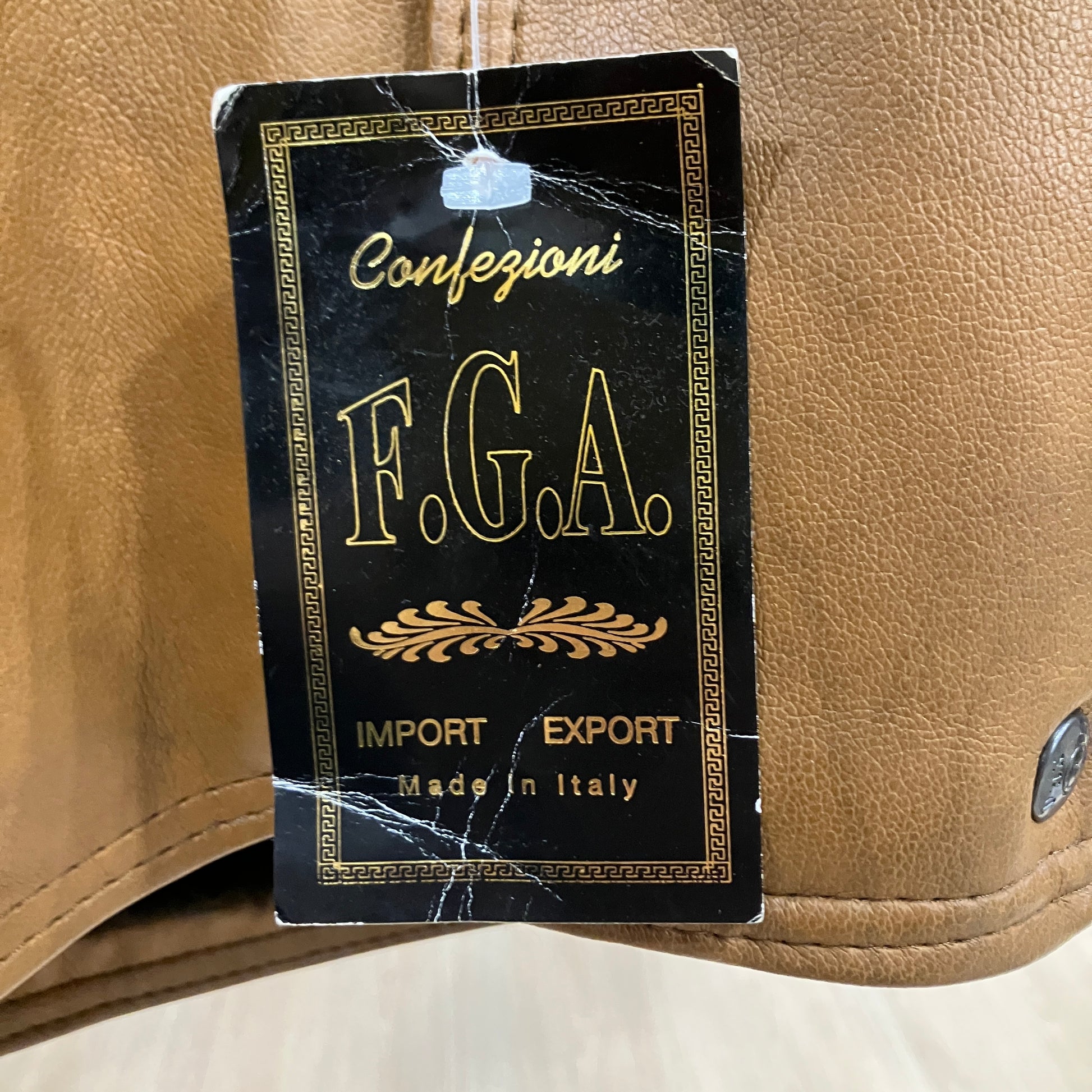 F.G.A. label on a beige leather product with 'Import Export Made in Italy' text