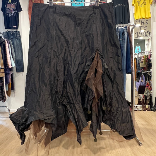 Black textured skirt on a rack in a store setting with various clothing items in the background