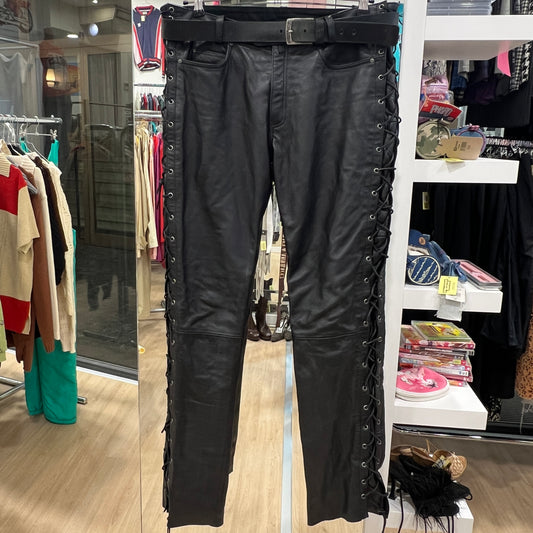 Black leather pants with lace-up sides on a rack in a store setting
