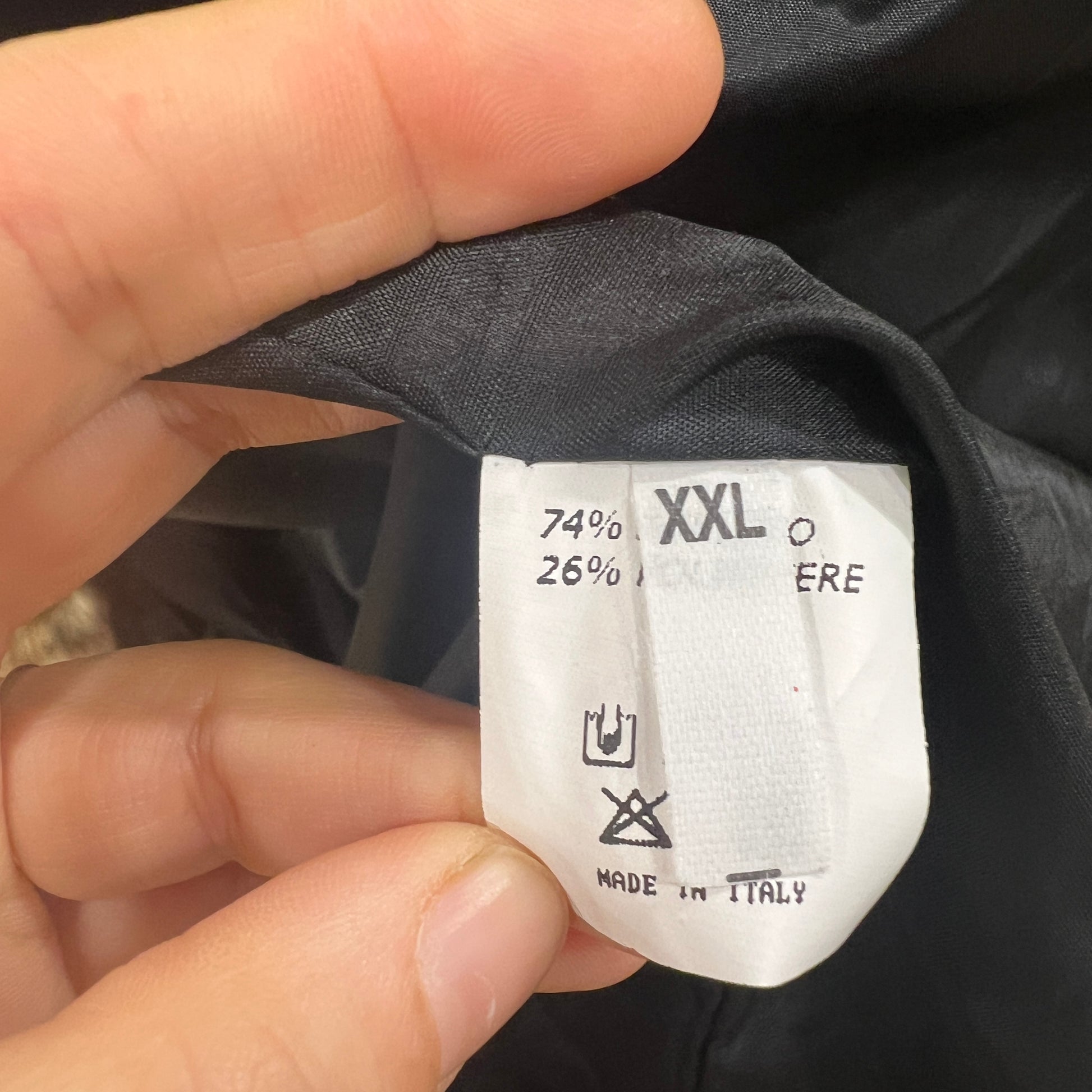 Clothing label with text and symbols held by a hand