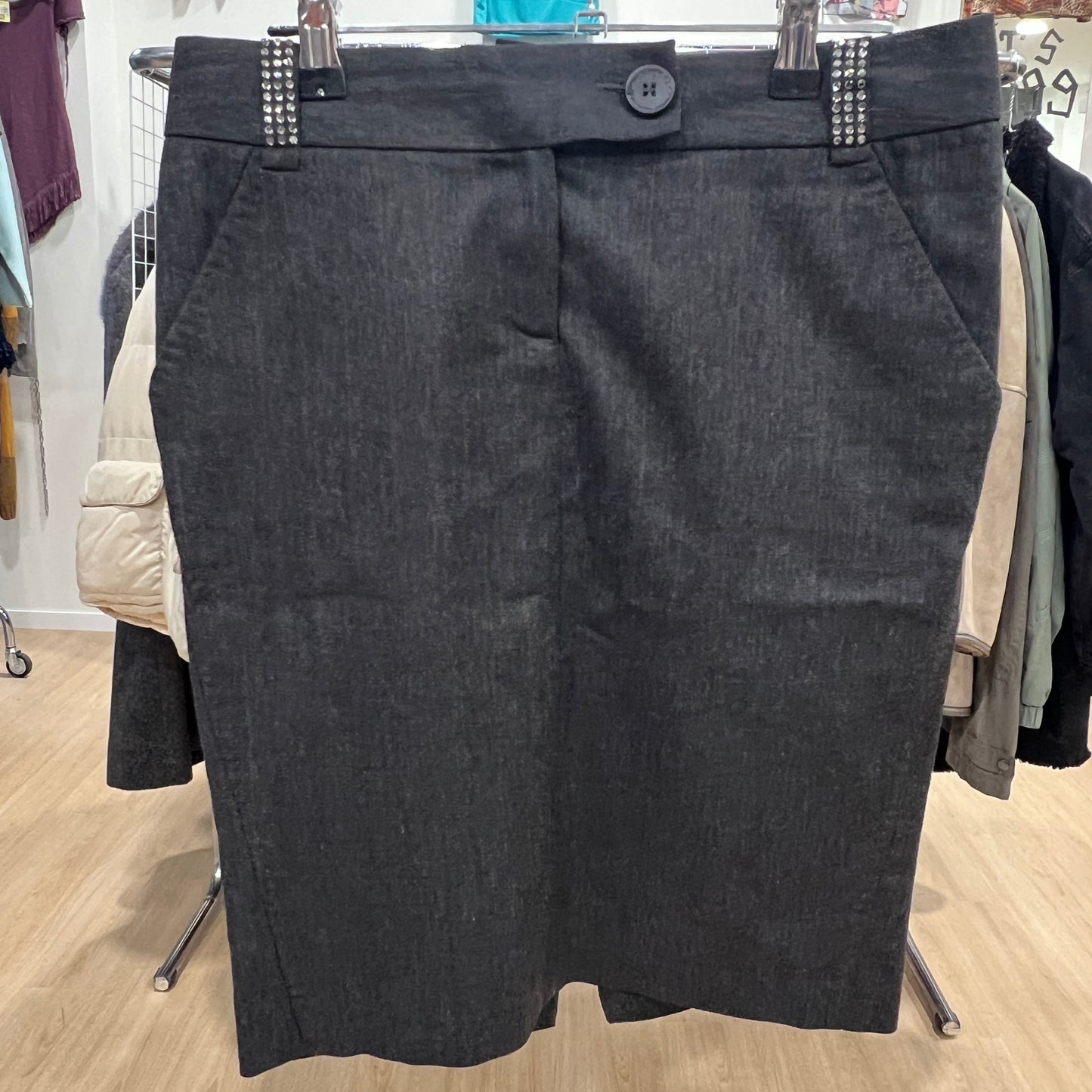 Dark gray skirt on a hanger in a store setting