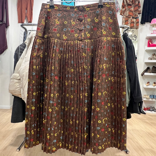 Brown pleated skirt with floral pattern on a clothing rack in a store