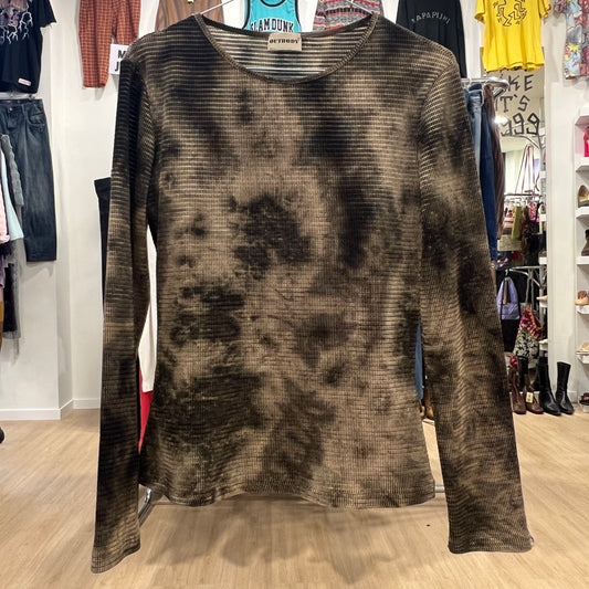 Tie-dye long-sleeve shirt on a hanger in a store setting