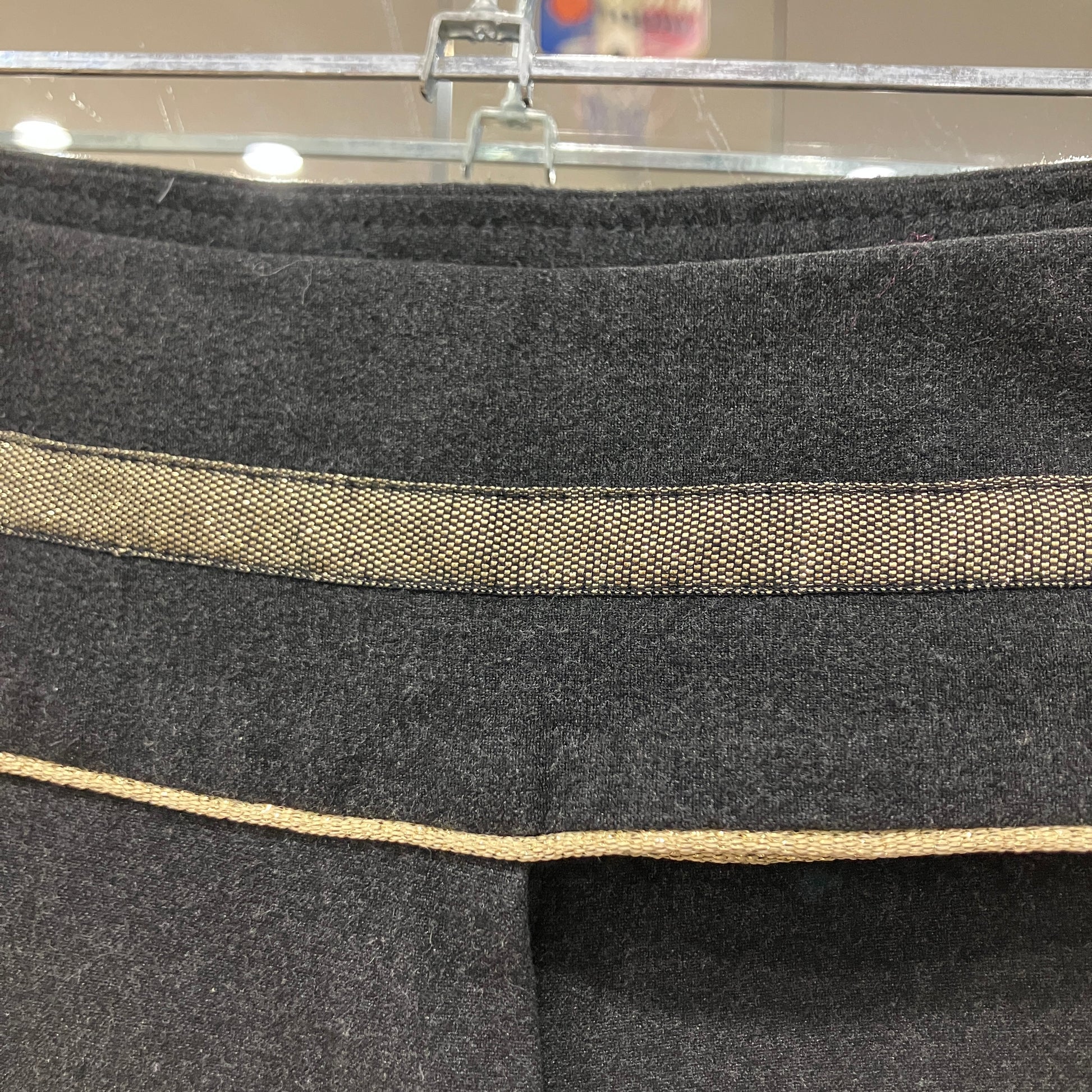 Close-up of a gray fabric with a gold trim on a hanger